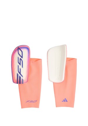Para różowych ochraniaczy na piszczele do piłki nożnej z twardymi płytkami ochronnymi, jeden z logo F50, drugi z logo Adidas na rękawie.