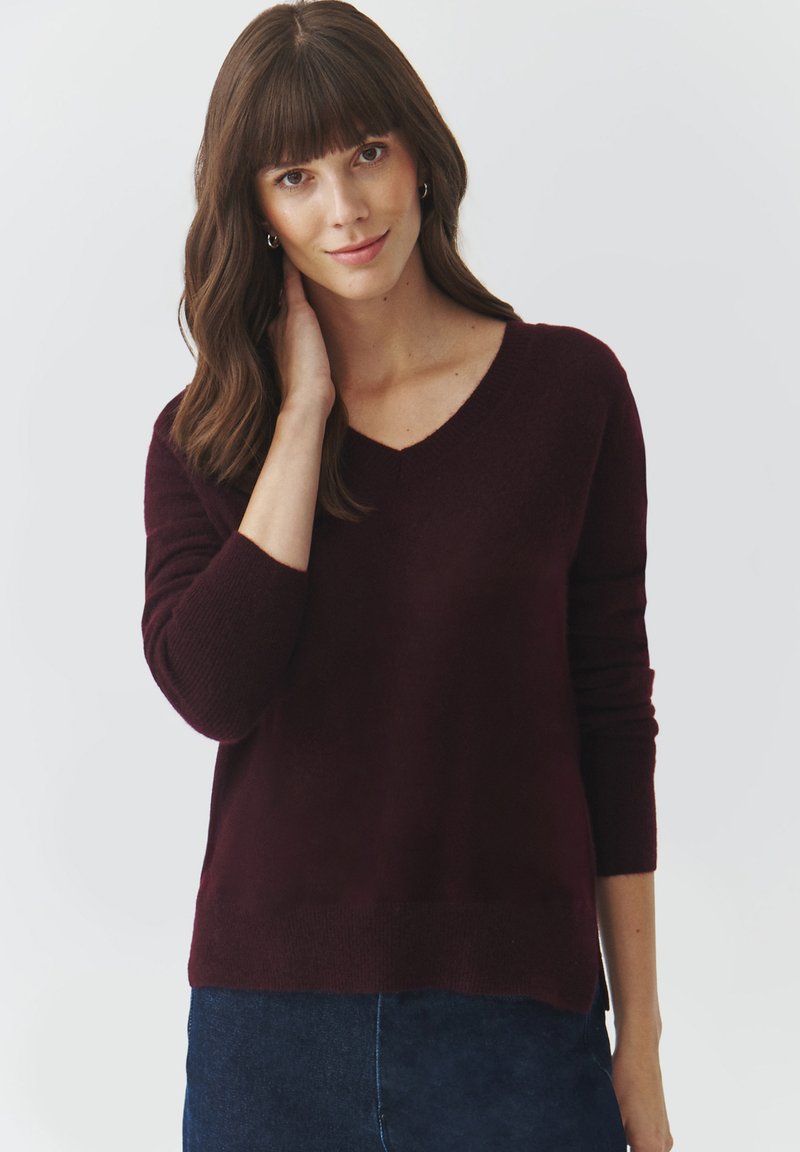 Maglione a maglia borgogna con scollo a V, maniche lunghe e vestibilità rilassata. Texture morbida con polsini e orlo a costine.