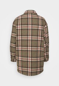Camisa de franela a cuadros en verde oliva, con patrones en rosa y negro, cuello, mangas largas y un corte holgado. Vista trasera mostrada.