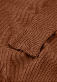 Ribbed, rust-colored fabric with a soft texture and fitted cuff detail. The material features a subtle, consistent pattern throughout.