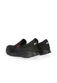 Scarpe slip-on nere realizzate in mesh traspirante e materiale in gomma, con una superficie testurizzata e un design minimalista. Logo "BT" sul tallone.