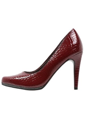 Lśniący burgundowy but na wysokim obcasie z teksturą przypominającą skórę gada, zaokrąglony czubek i smukły obcas. Posiada czarną lamówkę wzdłuż podeszwy.