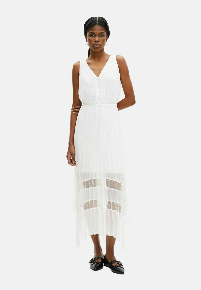 Abito maxi bianco con scollo a V e dettagli con bottoni, caratterizzato da un pannello trasparente con strisce orizzontali. Tessuto morbido, silhouette fluida.