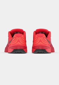 Κόκκινα αθλητικά παπούτσια με υφή από πλέγμα, έντονο σχέδιο στη φτέρνα και μαύρη εξωτερική σόλα με σχέδια πρόσφυσης.