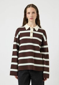 Brązowo-kremowy pulower w paski z kołnierzykiem, trzema guzikami, luźnym krojem i długimi rękawami. Miękka tekstura z kontrastującymi jasnoniebieskimi paskami.