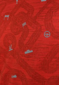 Röd tyg med mörkröd abstrakt racerbana mönster och små grå ikoner inklusive ett ratt, rutig flagga, mållinje och "s1r"-text.