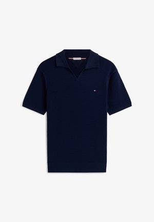 Polo a maniche corte in maglia blu navy con tessuto strutturato, piccolo logo rosso, bianco e blu sul petto e colletto a V.