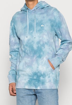 Felpa con cappuccio tie-dye azzurro chiaro con tasca a marsupio e cappuccio con cordino. Presenta un logo sul petto e polsini a costine a contrasto.