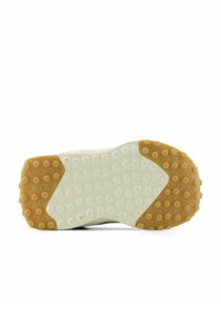 Semelle de chaussure avec une section centrale blanche et des zones de talon et d'orteil en caoutchouc beige, présentant des motifs de préhension circulaires pour une meilleure traction.