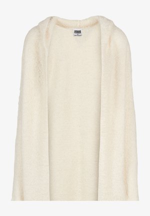 Long cardigan couleur crème en tissu tricot doux. Présente un devant ouvert et des manches longues avec une finition légèrement texturée.