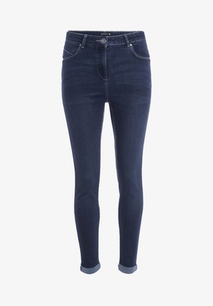 Dark blue denim skinny jeans with a high waist, rolled cuffs, front pockets, and contrast stitching detailing. Material appears smooth and stretchy.