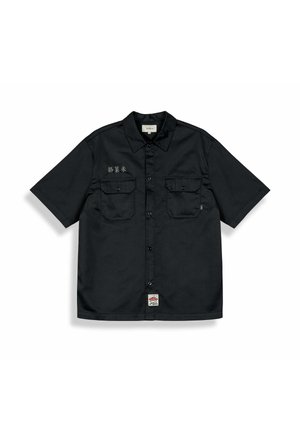 Schwarzes kurzärmeliges Hemd zum Zumachen mit zwei Klappentaschen auf der Brust, kleinem Etikett auf der linken Tasche, asiatischen Schriftzeichen auf der rechten Brust und einem Label am Saum.