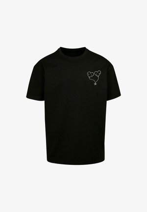 Mustat puuvillaiset t-paidat, joissa on yksinkertainen valkoinen grafiikka kahdesta sydämen muotoisesta ilmapallosta, joissa on kasvot, sijoitettuna vasempaan rintapaneeliin.