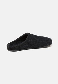Black wool felt slip-on slipper with a closed toe and low back, shown from the side on a white background.