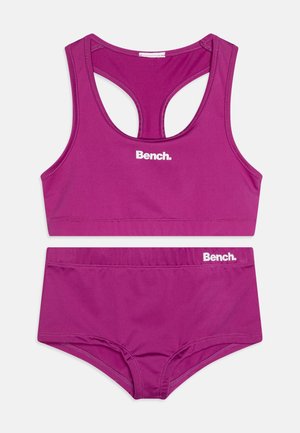 Conjunto de bikini desportivo roxo feito de tecido elástico. Apresenta um top estilo tank com costas em recorte e parte inferior de cintura alta combinada. Logótipo da marca exibido.