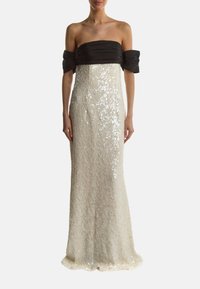 Trägerloses Kleid mit einem schwarzen, gerafften Oberteil und einem weißen, mit Pailletten verzierten Rock. Design in Fußlänge mit einer figurschmeichelnden Silhouette und einem ausgestellten Saum.