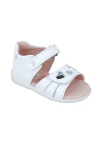 Sandalia de cuero blanca con tira de gancho y lazo, recortes en forma de corazón y una plantilla rosa suave. Presenta un diseño a rayas en la parte superior y suela blanca.