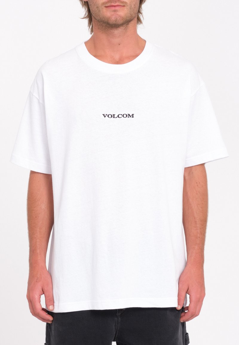 Hvid bomulds t-shirt med et sort "VOLCOM" logo på brystet. Den har en afslappet pasform, korte ærmer og en rund halsudskæring.
