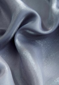 Világoskék szatén anyag sima, fényes felülettel, lágy redőkkel és finom fényvisszaverő hatásokkal.