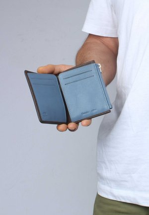 Blaues Leder-Portemonnaie mit einem Reißverschlussfach, Kartenfächern und braunen Akzenten. Verfügt über eine glatte Textur und eine genähte Kante für Haltbarkeit.