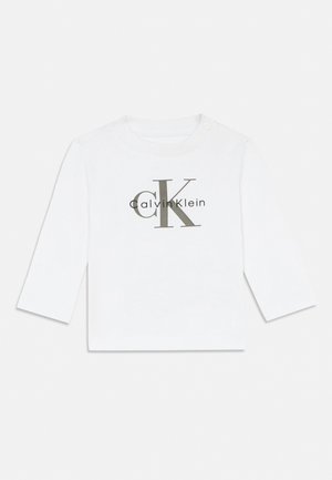 Witte babyshirt met lange mouwen en het Calvin Klein "cK"-logo centraal op de borst, met een drukknoop op de schouder.
