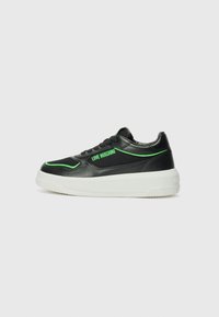 Zwarte sneaker met groene accenten, gemaakt van leer en mesh materiaal, ronde neus, platte witte zool en het "LOVE MOSCHINO" logo aan de zijkant.