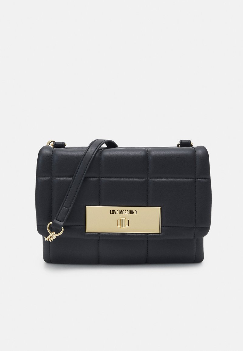 Borsa a tracolla nera in ecopelle trapuntata con una placca logo in tonalità oro e tracolla rimovibile, caratterizzata da una forma rettangolare e una texture liscia.