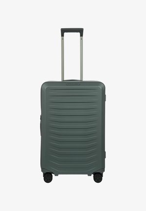 Valigia rigida di colore verde scuro, con una superficie texture a rilievo, manico retrattile e quattro ruote nere per facilitare la mobilità.