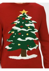 Czerwony sweter z dzianiny z zielonym wzorem choinki bożonarodzeniowej, białymi akcentami śniegu, żółtymi i czerwonymi ozdobami oraz żółtą gwiazdą na szczycie.