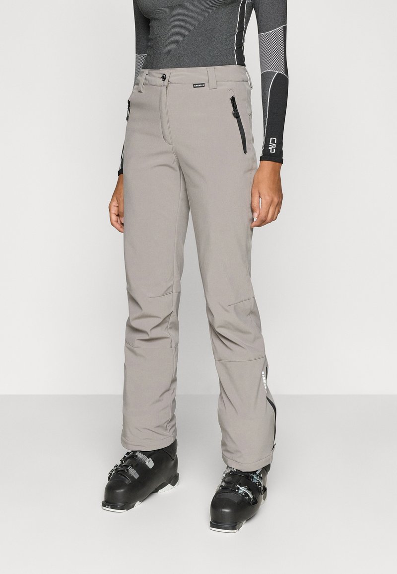 Hallid suusapüksid voolujoonelise disainiga, millel on lukuga taskud ja silekate tekstuur. Ühildatud mustade suusasaabastega talvistes tegevustes.