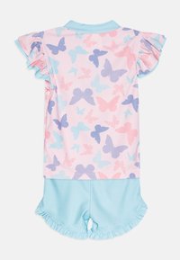 Ροζ σετ πιτζάμας με σχέδιο πεταλούδας σε μπλε και ροζ. Το τοπ έχει φούσκες μανίκια; οι σορτς είναι ανοιχτού μπλε με πουά και φούστα.