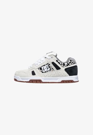 Valkoiset ja mustat sneakersit, joissa on mokkaa ja verkkomateriaaleja, leopardikuosiset yksityiskohdat, rei'ityksiä hengittävyyden parantamiseksi ja kumipohja.