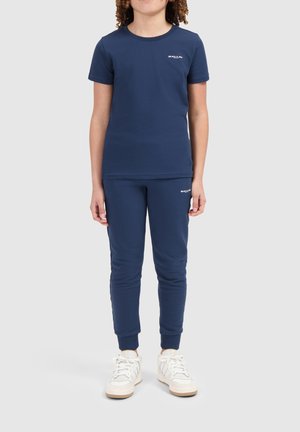 Navyblauwe T-shirt met korte mouwen en bijpassende joggers van zachte stof, met een logo-detail op de borst en heup. Een getailleerd ontwerp.