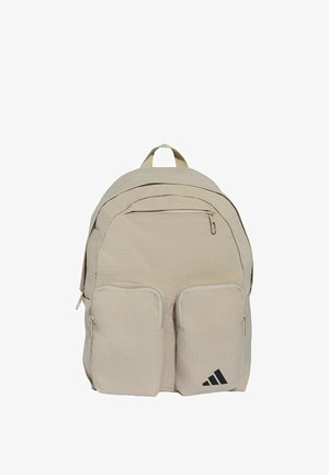 Mochila beige con múltiples compartimentos con cremallera y dos bolsillos frontales, con un logo negro de Adidas en el bolsillo inferior derecho.