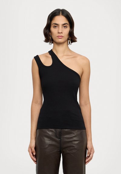 Débardeur noir ajusté avec un design à une épaule, texture côtelée et encolure incurvée, associé à un pantalon en cuir marron taille haute.
