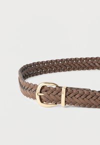 Πλεκτή καφέ δερμάτινη ζώνη με χρυσή μεταλλική αγκράφα και διακοσμητικό στοιχείο. Ο σχεδιασμός παρουσιάζει περίτεχνο πλέξιμο και ομαλή υφή.
