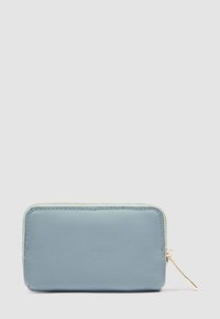 Portefeuille compact rectangulaire en cuir bleu clair avec une fermeture éclair dorée et un curseur sur un fond gris clair.
