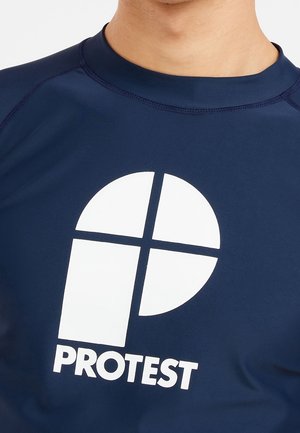 Camiseta de protección azul marino hecha de tela elástica, con un gran logo blanco que consiste en un cuadrado redondeado y el texto "PROTEST" en la parte inferior.