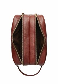 Bruine leren handtas met drie ritssluitingen. Bevat ritssluitingen in goudkleur en een gladde textuur, wat de afgeronde, gestructureerde vorm benadrukt.