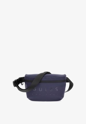 Tmavě modrá ledvinka vyrobená z hladkého syntetického materiálu, se zlaceným logo "GUESS EST. 1981", nastavitelným popruhem a zipovým uzávěrem.