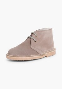 Stivale alla caviglia in suede grigio con punta rotonda, design con lacci a due occhielli e suola in gomma beige. Presenta cuciture minime e una texture liscia.