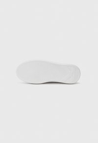 White sneaker sole featuring a textured pattern with wavy grooves and a rounded toe. Clean design with minimal branding visible.