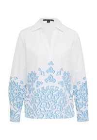 Witte blouse met lange mouwen en een v-hals, versierd met een blauw abstract patroon aan de onderkant en op de mouwen. Gemaakt van een lichte stof.