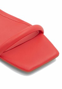 Röd lädersandaler med fyrkantig tå och en tunn rem. Slät textur med neutral sula och minimalistisk design.