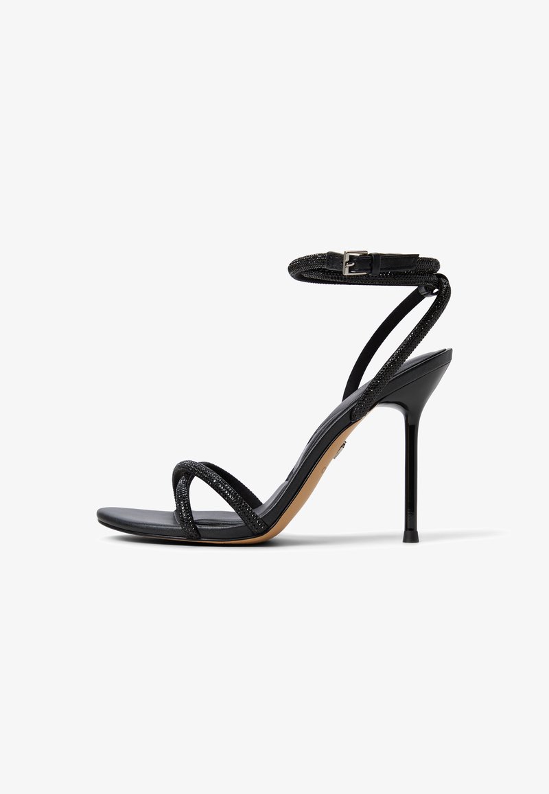 Schwarze Sandalette mit hohem Absatz und dünnen Riemen, mit einem strukturierten Knöchelriemen und glattem Fußbett. Schlankes Design mit spitzer Zehenpartie und Stöckelabsatz.