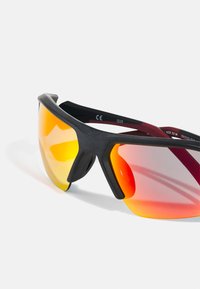 Occhiali da sole sportivi con montatura nera, lenti a specchio giallo-rosse e un design elegante caratterizzato da una forma curva e aperture di ventilazione.