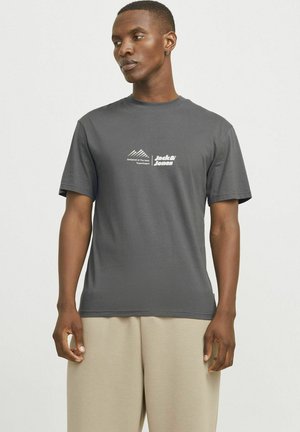 Grå bomulds t-shirt med korte ærmer, rund hals og et hvidt logo med bjerge og tekst på venstre brystområde.