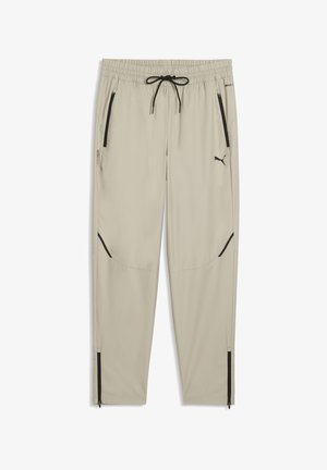 Hellbeige Jogginghosen aus leichtem Stoff. Mit elastischem Bund und Kordelzug, Reißverschlusstaschen und schwarzen Akzenten.