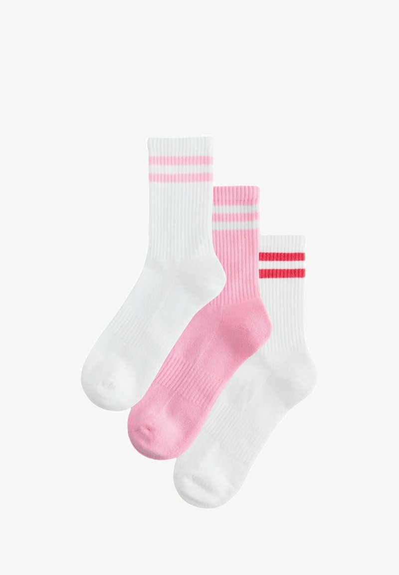 Trois paires de chaussettes de cheville : deux blanches avec des rayures rose et rouge, une rose unie. Texture côtelée, matériaux doux, hauteurs variées.