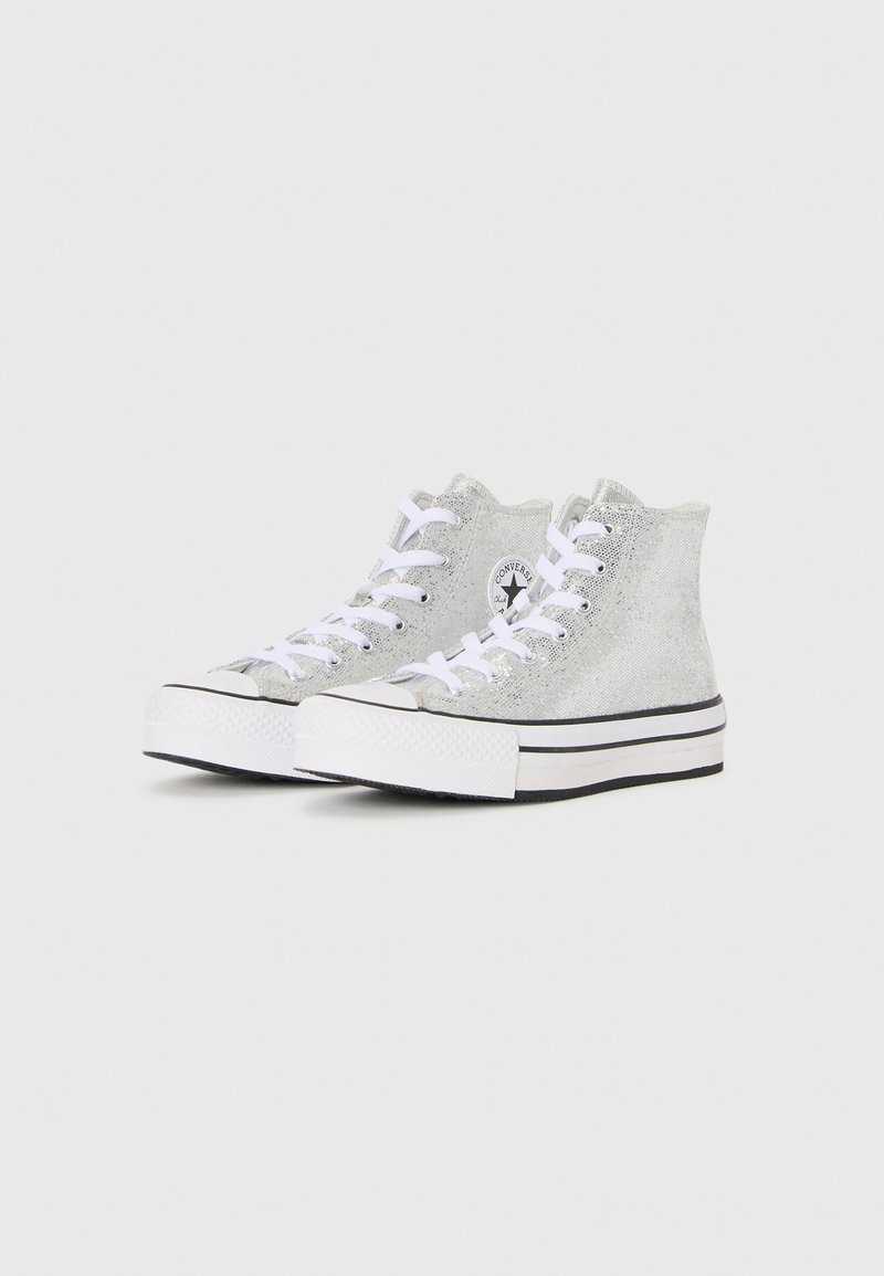 Zapatillas altas en tejido de purpurina plateada, con cordones blancos, suela de goma negra con franjas blancas y un parche redondo con el logo.